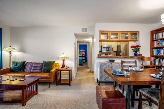 living area featuring light colored carpet and visible vents