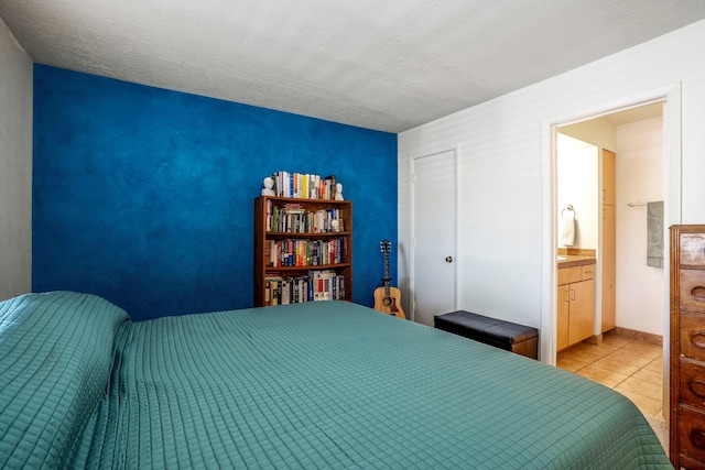 bedroom with light tile patterned floors, baseboards, and a textured ceiling