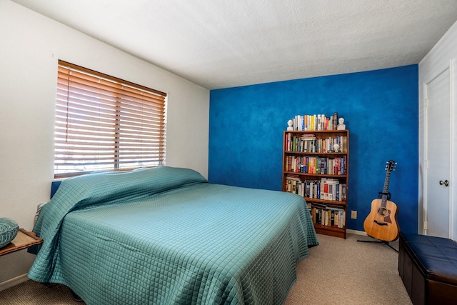 carpeted bedroom featuring baseboards and a textured ceiling