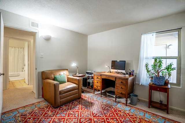 carpeted home office featuring baseboards, visible vents, and a textured ceiling