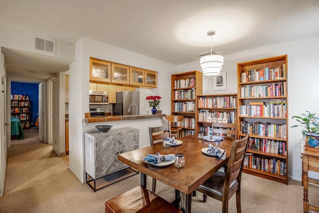 dining area with light carpet and visible vents