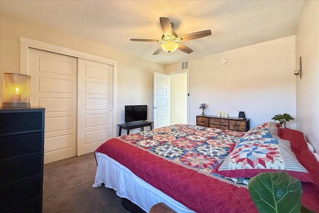 carpeted bedroom featuring visible vents, a textured ceiling, a ceiling fan, and a closet