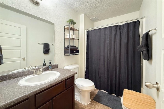 bathroom featuring toilet, curtained shower, tile patterned flooring, a textured ceiling, and vanity