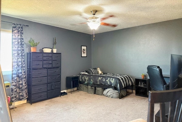 bedroom with a textured ceiling, carpet flooring, and a ceiling fan