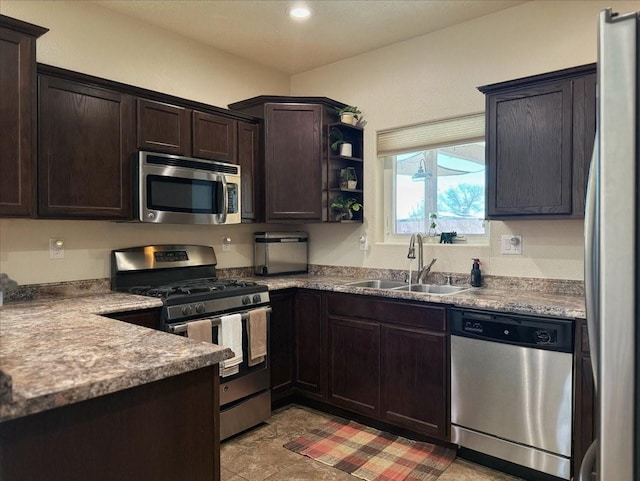 kitchen featuring appliances with stainless steel finishes, dark brown cabinets, and a sink