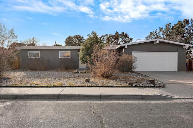 view of front of house featuring a garage, concrete driveway, and stucco siding