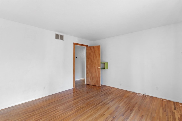 empty room featuring visible vents and wood finished floors