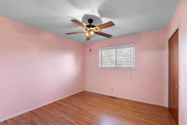 unfurnished bedroom featuring light wood-style flooring, a closet, visible vents, and baseboards