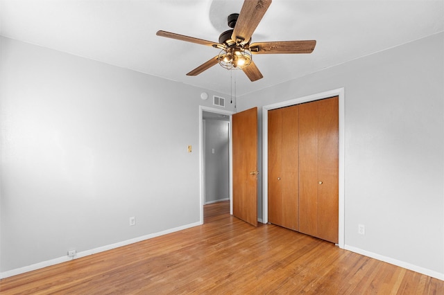 unfurnished bedroom with a closet, light wood-type flooring, a ceiling fan, and baseboards