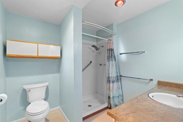 full bath with a stall shower, vanity, toilet, and baseboards