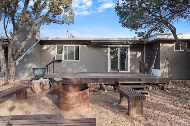 rear view of property with a deck and stucco siding