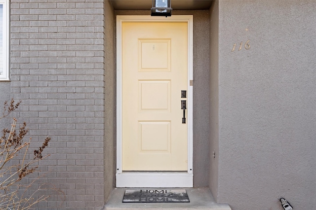 entrance to property featuring stucco siding