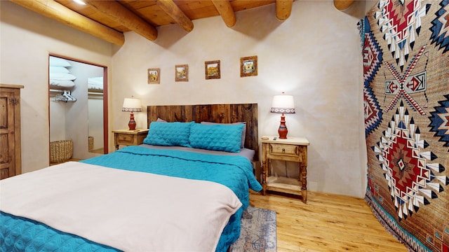 bedroom featuring wood ceiling, light wood-type flooring, and beam ceiling