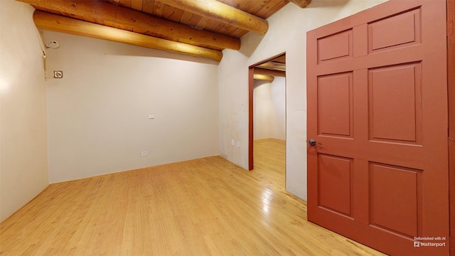 spare room with beamed ceiling, light wood-type flooring, and wooden ceiling