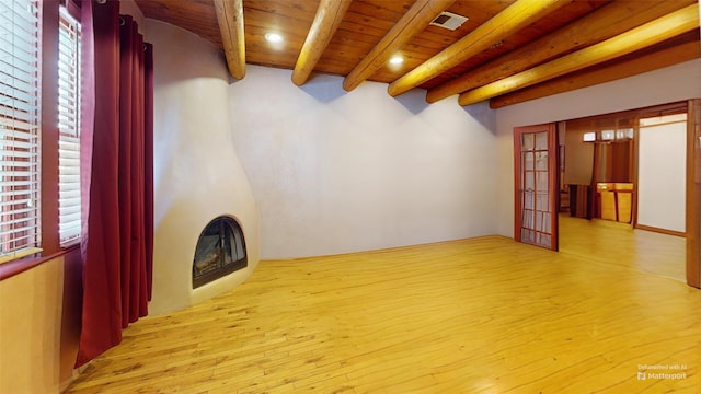 unfurnished living room featuring wood ceiling, visible vents, light wood-style flooring, and beam ceiling