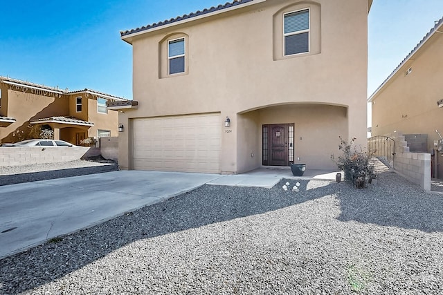 view of front facade with a garage, driveway, a tiled roof, a gate, and stucco siding