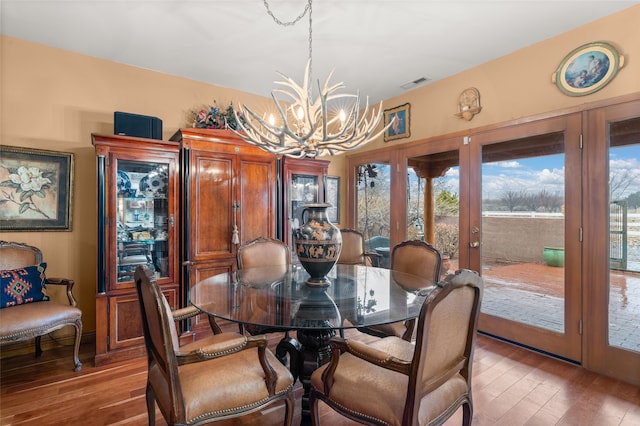 dining room featuring a chandelier, light wood-type flooring, and visible vents