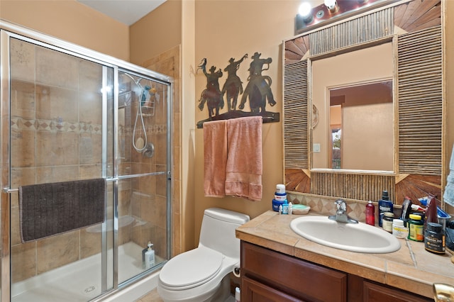 full bathroom featuring a stall shower, vanity, and toilet