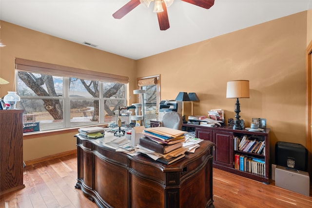 office area with baseboards, ceiling fan, visible vents, and light wood-style floors