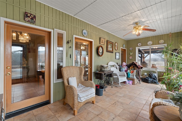 sunroom featuring wooden ceiling and ceiling fan with notable chandelier