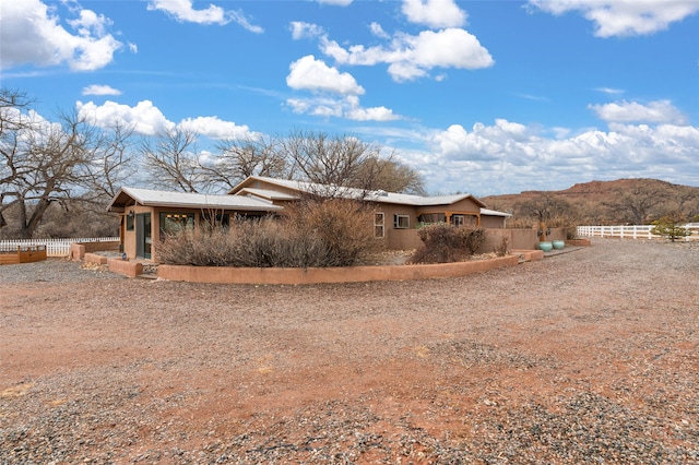 view of property exterior featuring fence and a mountain view