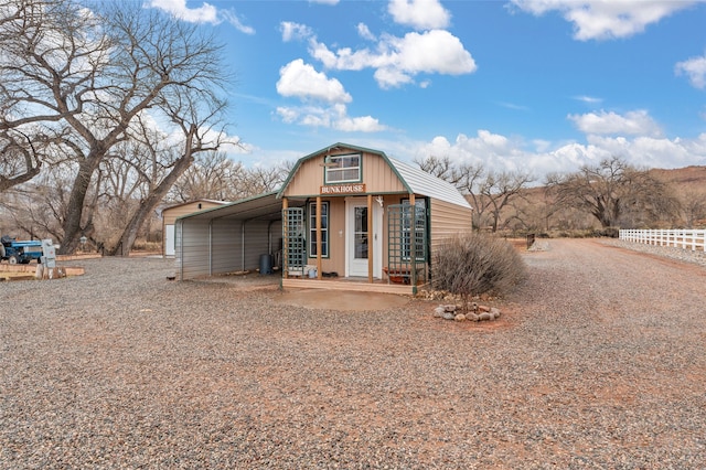 view of front of house featuring gravel driveway and a gambrel roof