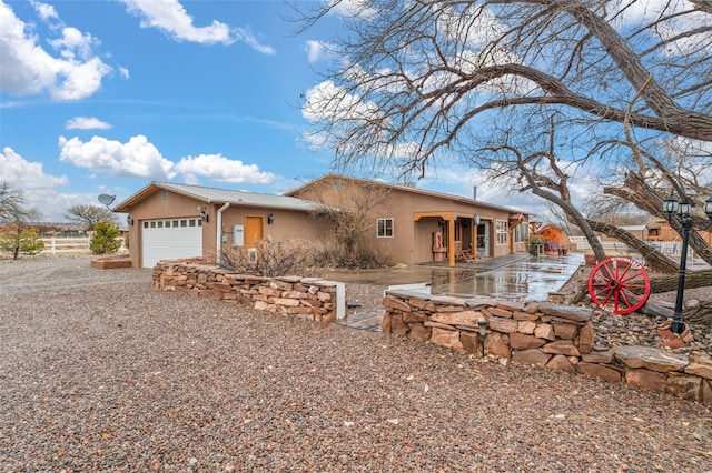 single story home with a garage, fence, and stucco siding