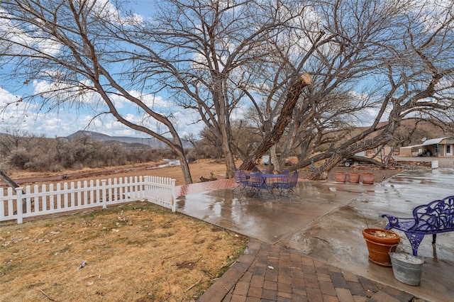 view of yard with a patio, fence, and a mountain view