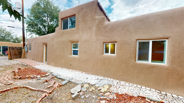 view of side of property featuring fence and stucco siding