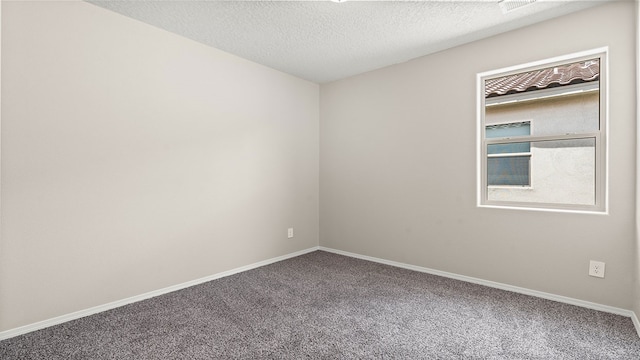 carpeted empty room featuring baseboards and a textured ceiling