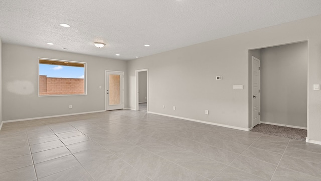 unfurnished room with light tile patterned floors, baseboards, a textured ceiling, and recessed lighting