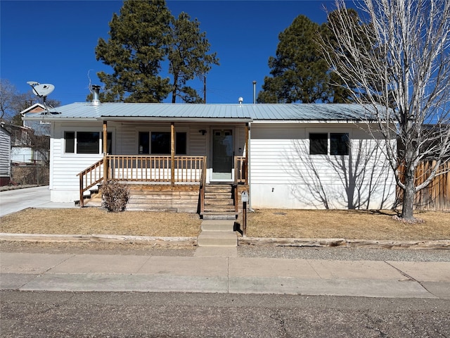 view of front of property with covered porch, metal roof, and crawl space