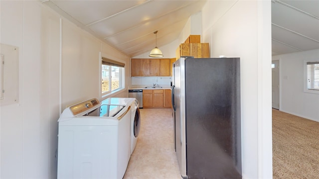 kitchen with lofted ceiling, a healthy amount of sunlight, appliances with stainless steel finishes, and independent washer and dryer