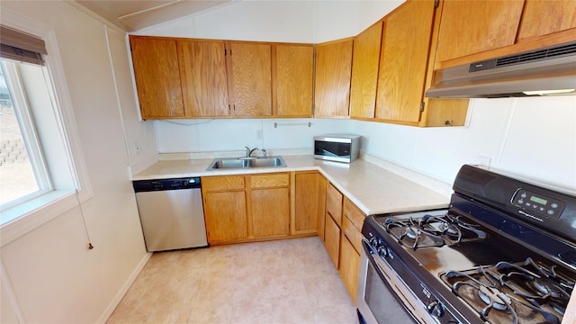 kitchen with under cabinet range hood, stainless steel appliances, a sink, and light countertops