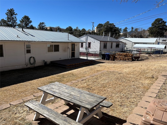 rear view of property featuring metal roof and fence