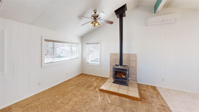 unfurnished living room featuring a ceiling fan, a wood stove, a wall mounted air conditioner, and vaulted ceiling with beams