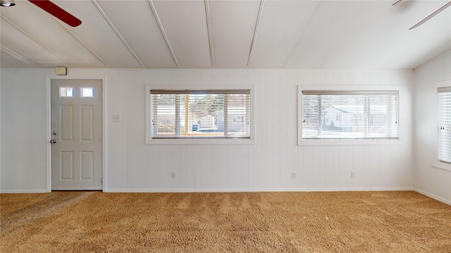 foyer entrance featuring vaulted ceiling and carpet flooring