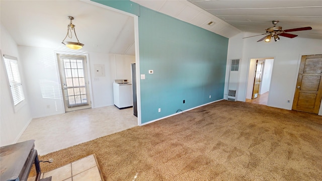 unfurnished living room with ceiling fan, carpet flooring, visible vents, vaulted ceiling, and washer / clothes dryer