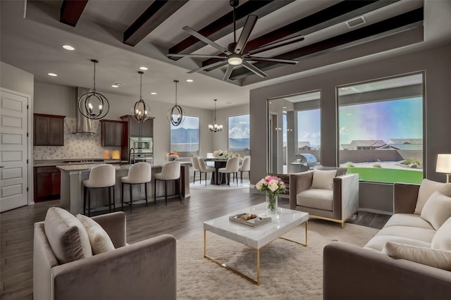 living area featuring a healthy amount of sunlight, light wood-style flooring, beamed ceiling, and recessed lighting