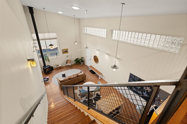 staircase featuring high vaulted ceiling and wood finished floors