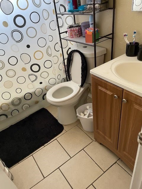 bathroom with toilet, tile patterned flooring, and vanity