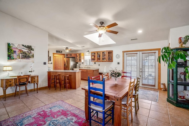 dining room featuring a healthy amount of sunlight, baseboards, light tile patterned flooring, and french doors