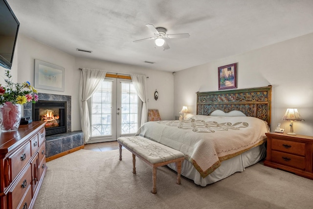 bedroom featuring access to outside, a premium fireplace, visible vents, and light colored carpet