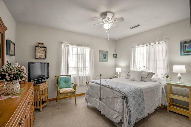 bedroom with light carpet, baseboards, visible vents, and a ceiling fan