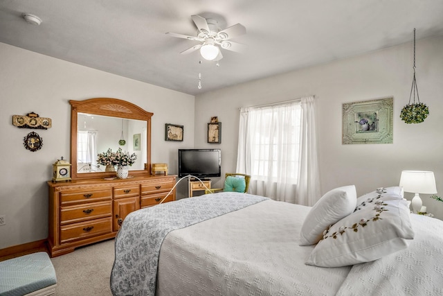 bedroom featuring light carpet, ceiling fan, and baseboards