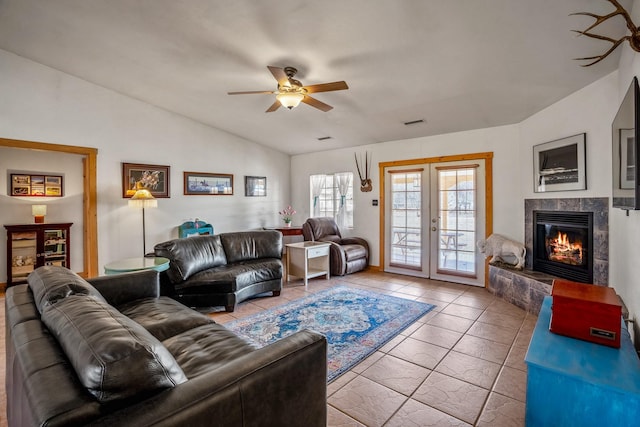 living room featuring visible vents, ceiling fan, vaulted ceiling, french doors, and a fireplace