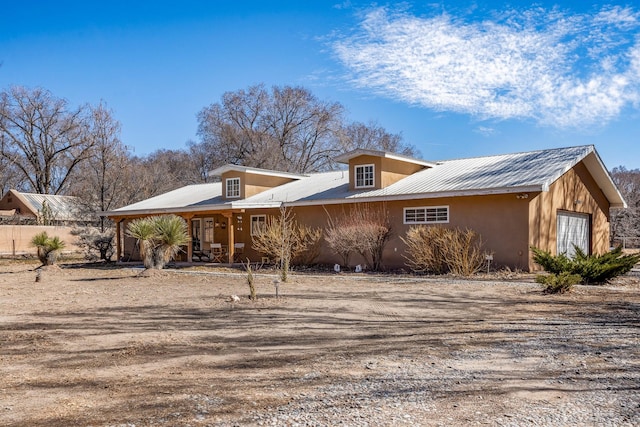 exterior space featuring metal roof and stucco siding