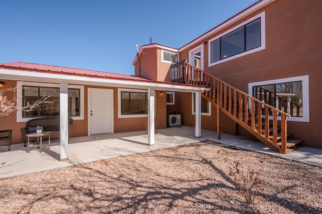 rear view of property featuring stucco siding and a patio