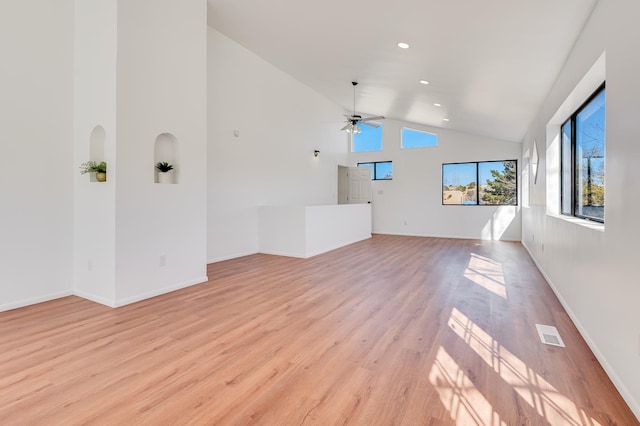 spare room with visible vents, baseboards, a ceiling fan, light wood-style floors, and high vaulted ceiling