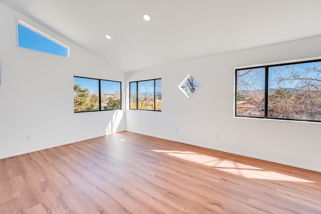 spare room featuring high vaulted ceiling, light wood-type flooring, baseboards, and recessed lighting